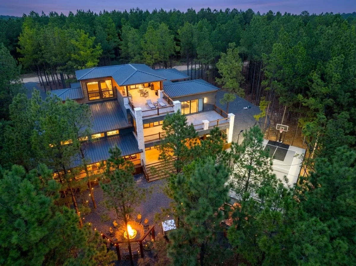 LivNLove luxury cabin in Broken Bow at twilight with illuminated decks and forested surroundings